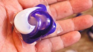 Person holding a laundry pod
